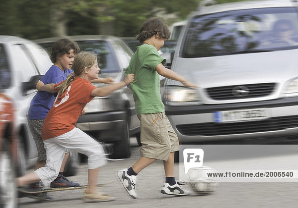 Unfallgefahr  Kinder rennen mit Ball über Straße