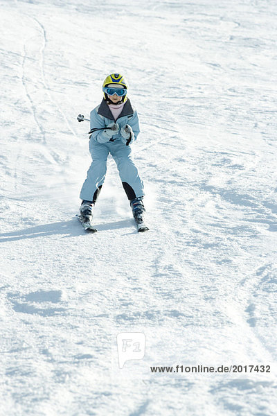 Girl skiing down ski slope  full length