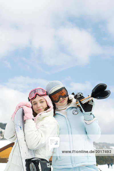 Zwei junge Skifahrer stehen zusammen  lächeln vor der Kamera  Porträt