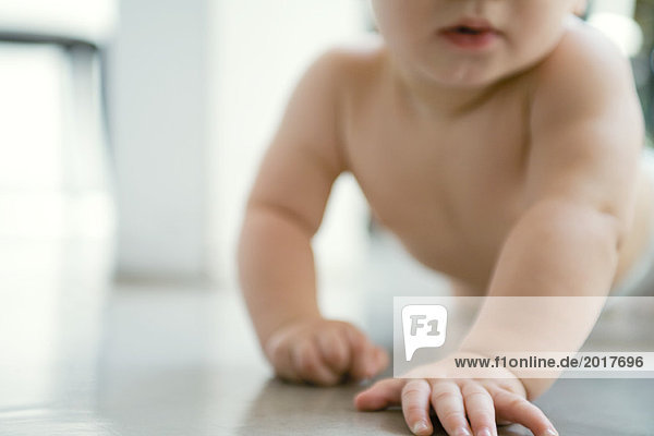 Baby krabbelt auf dem Boden  Ausschnittansicht