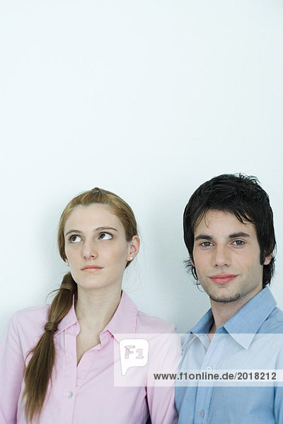 Young couple  man looking at camera while woman looks away  portrait