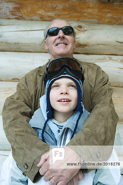 Großvater umarmt Enkel  gekleidet in Winterkleidung  Portrait