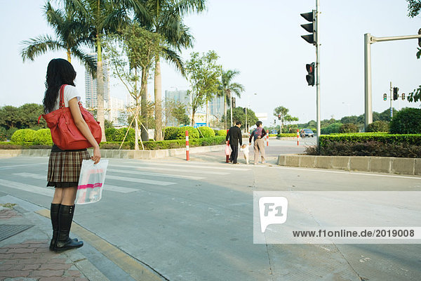 Young woman waiting to cross street