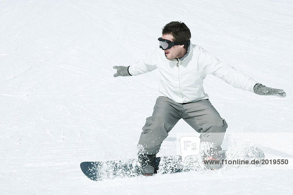 Young man snowboarding  action shot  full length