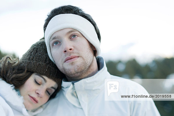 Young couple in snowy landscape  portrait