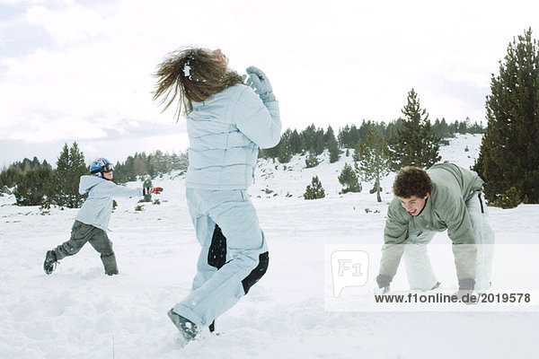 Young friends having snowball fight  action shot