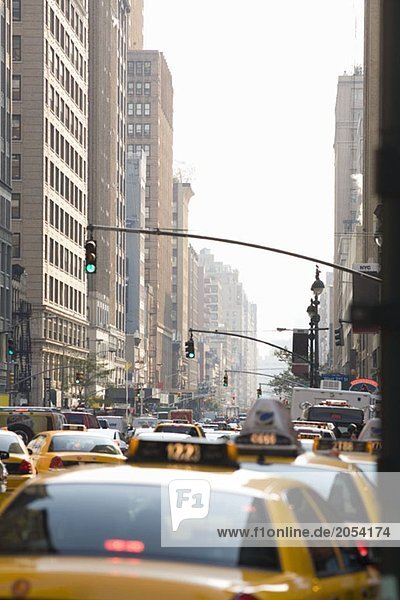 Taxis  die eine Straße in Manhattan hinunterfahren.