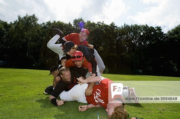 A baseball team piled on top of one another
