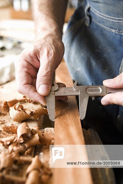 Detail eines Zimmermanns beim Messen von Holz
