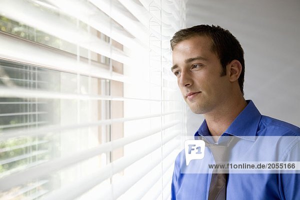 A young businessman staring out a window