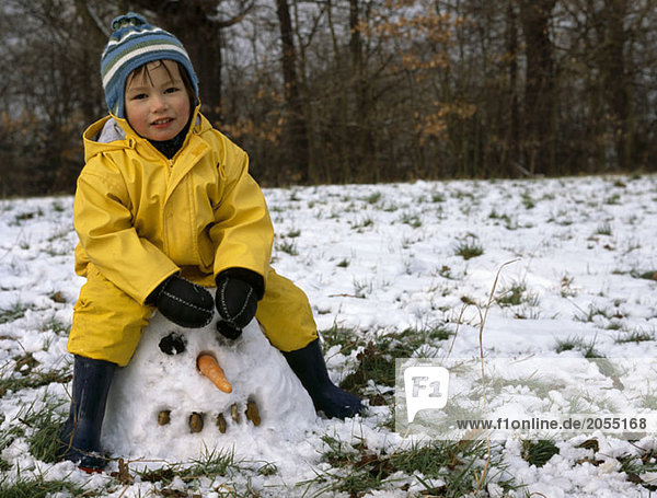 A young sitting on a snowman