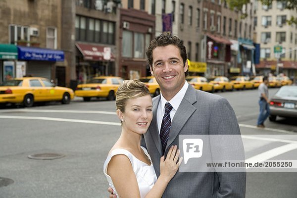 A bride and groom posing on a Manhattan street