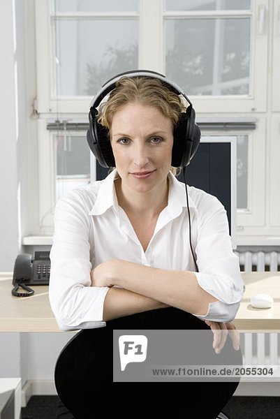 Eine Frau  die bei der Arbeit Musik hört.