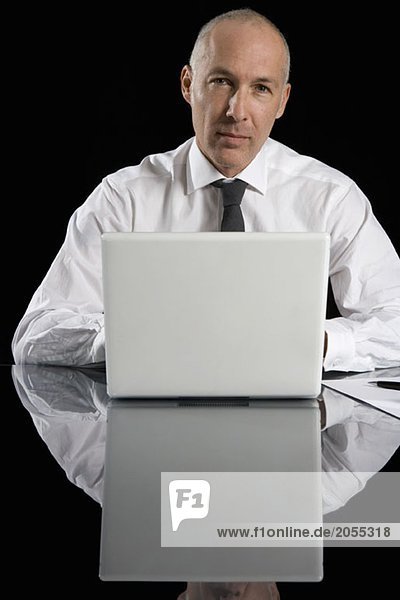 Ein Geschäftsmann  der einen Laptop benutzt.