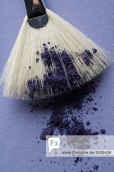 A make-up brush with purple eyeshadow