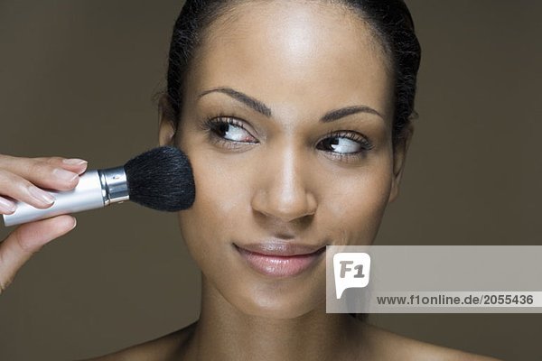 A woman applying face powder