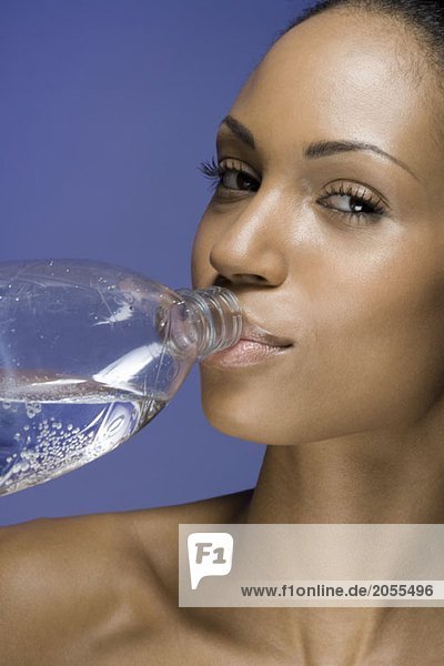 Eine Frau trinkt Wasser aus einer Flasche.