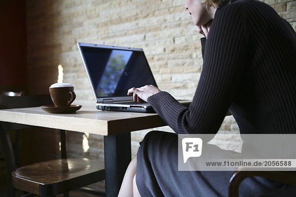 Eine Frau im Café am Laptop