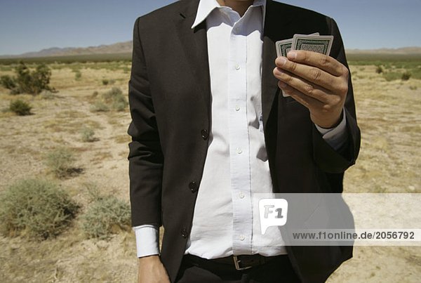 Ein Mann mit Spielkarten in der Wüste
