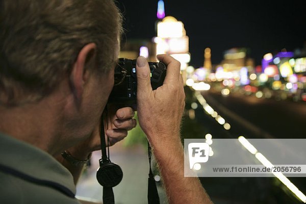 Ein älterer Mann macht ein Foto von den Straßen Las Vegas  nachts