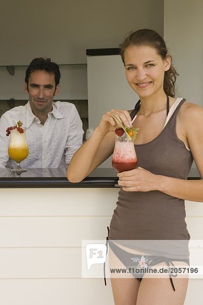 Ein Barkeeper und eine Frau mit Cocktails