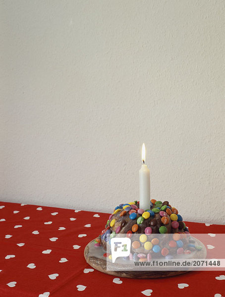 Süßigkeitenverzierter Schokoladenkuchen mit Geburtstagskerze