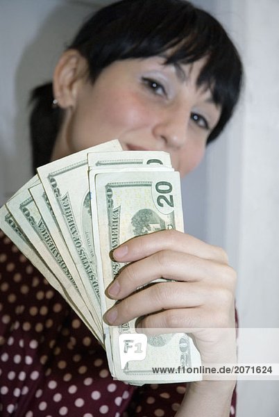 Junge Frau mit einer handvoll Dollarnoten