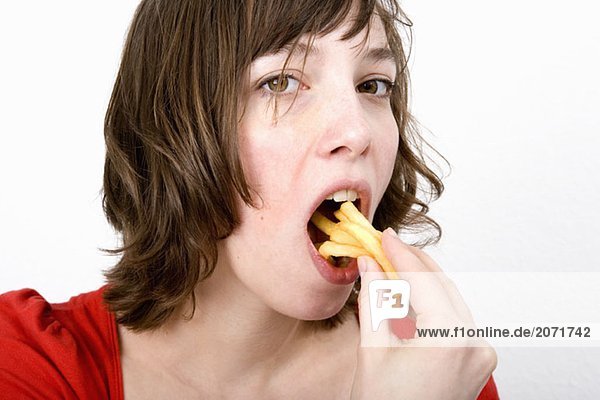Eine junge Frau isst Pommes Frites