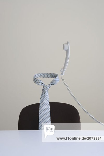 Krawatte und Telefon in der Luft schwebend hinter einem Schreibtisch