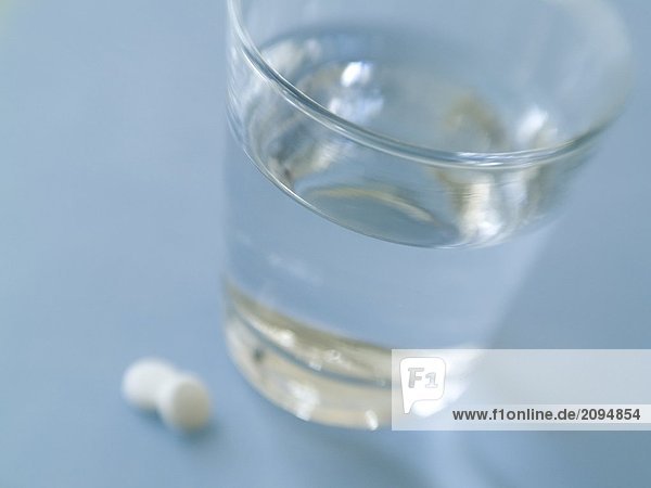 Nahaufnahme-Pillen und Glas Wasser