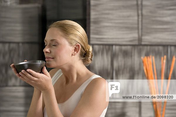 Deutschland  junge Frau mit Teeschale  Nahaufnahme