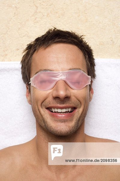 Germany  Man relaxing  wearing gel eye mask  close-up  portrait