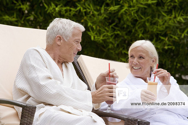 Germany  senior couple drinking smoothie in spa