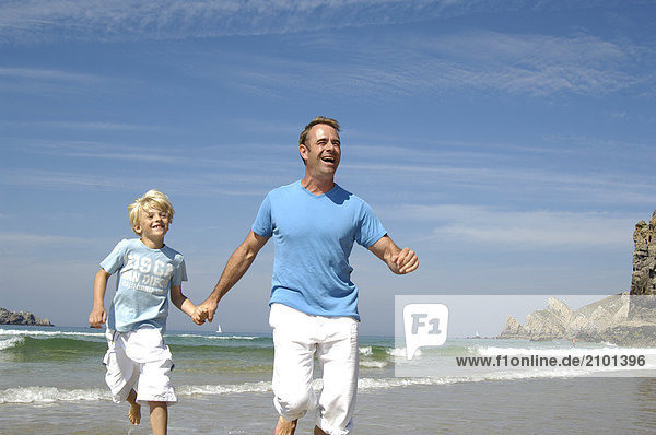 Man running with his son on beach
