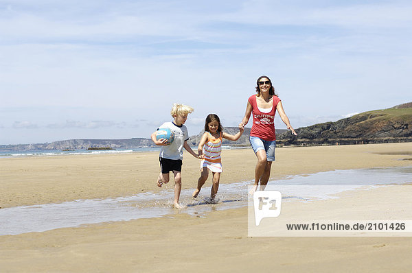 Frau mit ihren Kindern am Strand