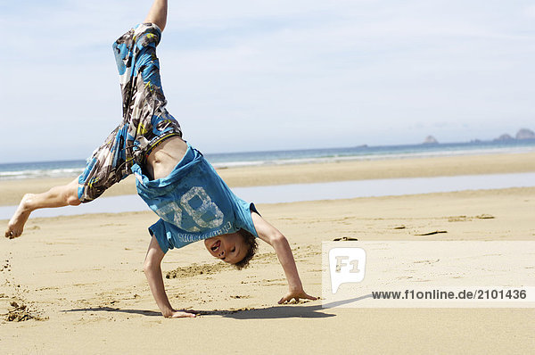 Boy doing cartwheel on beach