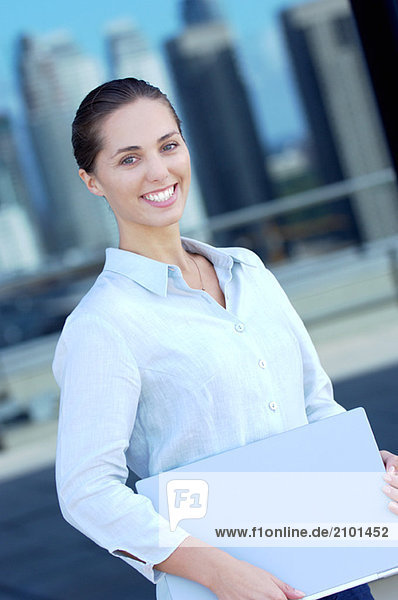 Businesswoman holding files  smiling  side view