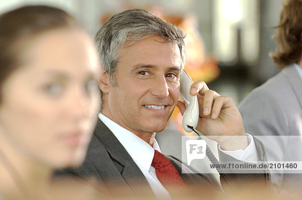 Businessman using telephone  smiling