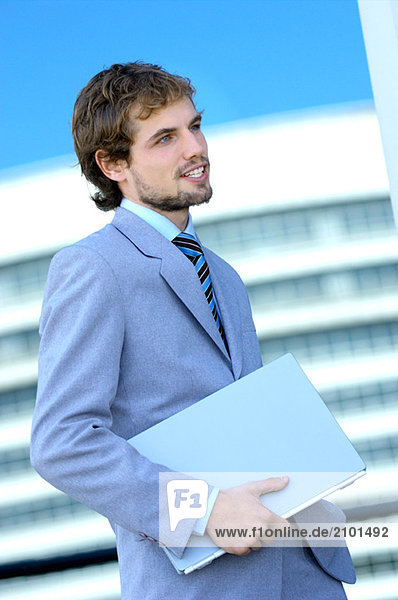 Young businessman holding file  side view
