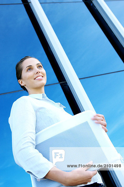 Young businesswoman standing by office building  low angle view
