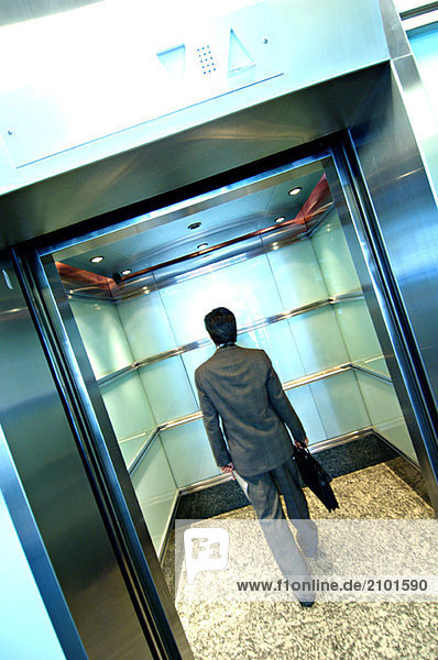 Businessman standing in elevator  rear view