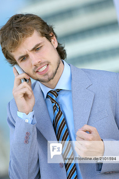 Businessman conversing on mobile phone  close-up