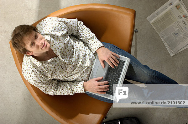 Junger Geschäftsmann mit Laptop  Portrait  Hochwinkelansicht