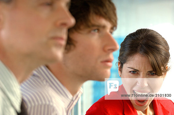 Businesswoman screaming with businessmen in foreground