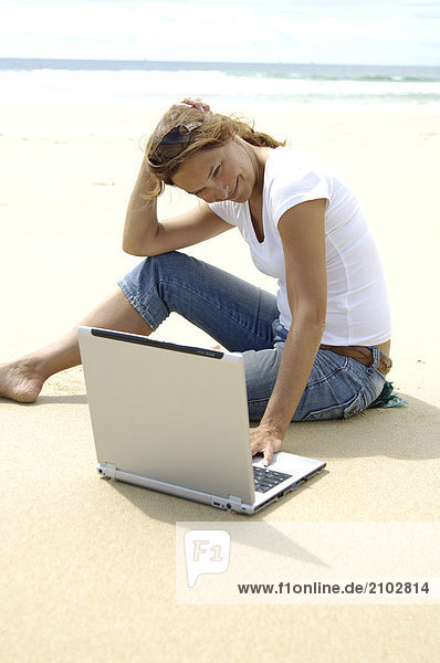 Nahaufnahme Frau mit Laptop am Strand