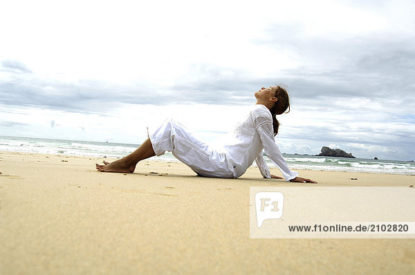 Seitenprofil Frau meditieren am Strand