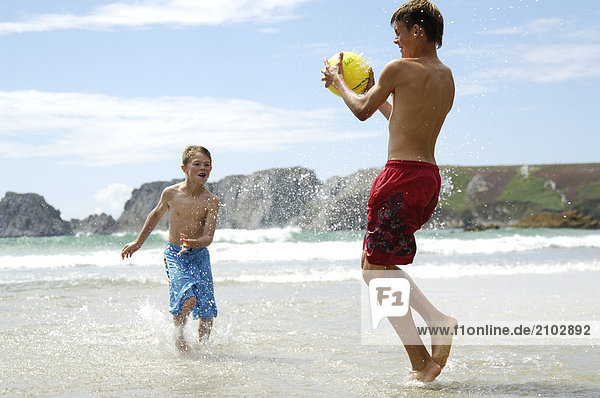 Strand Junge - Person 2 Ball Spielzeug spielen