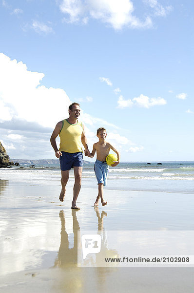 Father walking with his son on beach