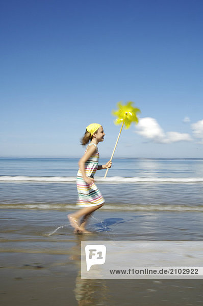 Seitenansicht Mädchen am Strand ausgeführt und halten eine Pin-Rad