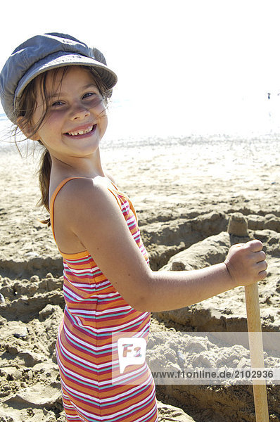 Porträt von Mädchen Stand mit Schaufel am Strand